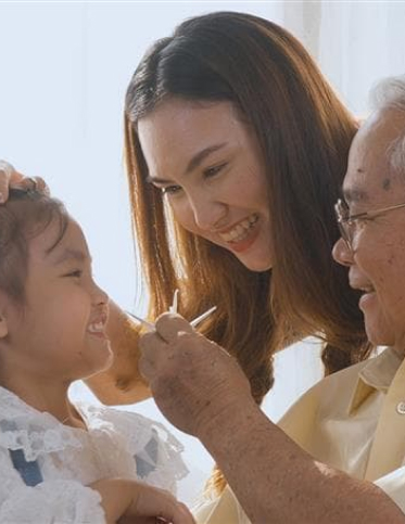 Asian grandaughter laughing with mother and grandfather
